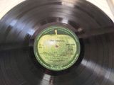vinyl record on a table with a green apple on top of it