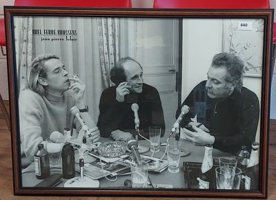 photo encadrée représentant un groupe de personnes assises à une table, un verre à la main