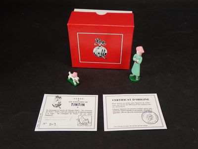 une boîte rouge sur laquelle sont posées deux petites figurines
