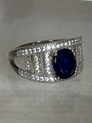 une image d'une bague avec une pierre bleue entourée de diamants