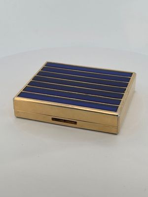 an image of a gold and blue cigarette case on a white surface