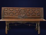 an old wooden bench with a carved design on it