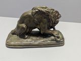 statue of a lion resting on a cushion on a white surface