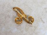 a gold brooch that is sitting on a table