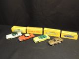 five toy cars are lined up in a row on a black surface