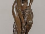 statue of a woman sitting on a rock on a wooden table