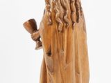 a wooden statue of a woman holding a pipe