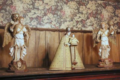 four statues of angels on a shelf in a room