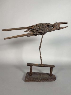 sculpture représentant un oiseau posé sur un banc, réalisée à partir de morceaux de bois