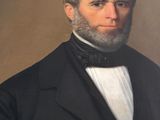 portrait of a man with a beard in a black coat and bow tie