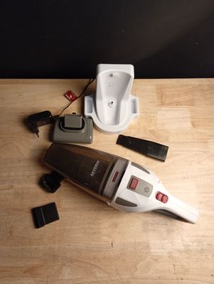 un aspirateur posé sur une table à côté d'un téléphone portable