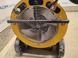 a yellow fan sitting on top of a cart in a warehouse