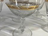 six glasses sitting on a table with gold rims