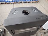 a black stove sitting on the side of the street