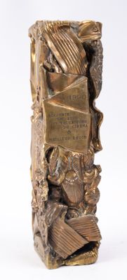 bronze sculpture of a bookend with a book on top of a pile of books