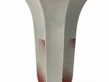 a white and red vase sitting on a white surface