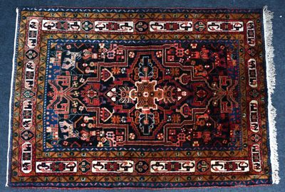 un tapis oriental posé sur une moquette bleue, orné d'un motif rouge et bleu