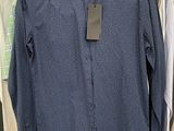 a blue shirt hanging on a rack in a clothing store
