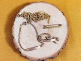 a piece of wood with a necklace and a pair of scissors on it