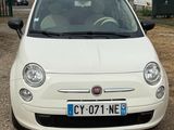 a small white car that is parked in a lot
