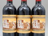 trois bouteilles de vin rouge posées sur une table blanche