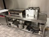un plan de travail en acier inoxydable sur lequel sont posés des casseroles et des poêles