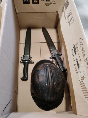 une boîte contenant deux couteaux et un casque