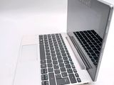 a white laptop with a black keyboard on a white table