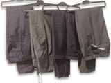 three pairs of pants hanging on a clothes rack on a hanger