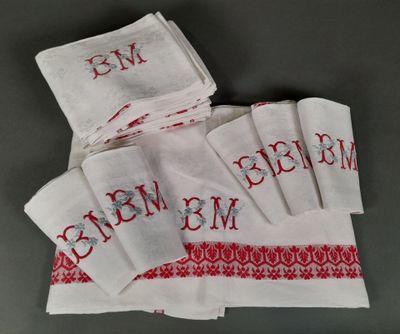 a close up of a pile of white towels with red letters on them