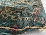 a green pillow with a decorative design on it