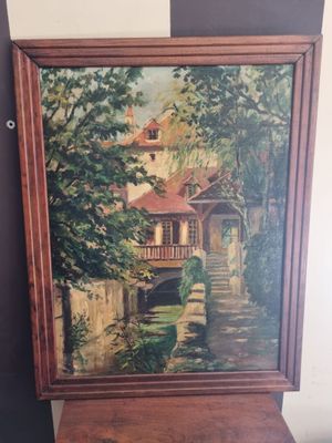 an oil painting of a house by a river in a wooden frame