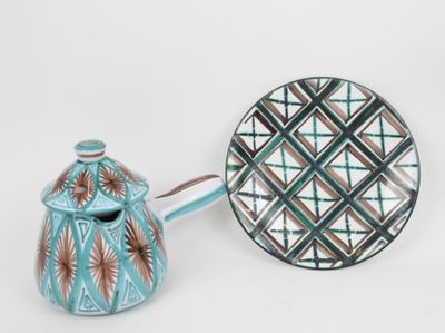une théière et une assiette posées sur une table blanche