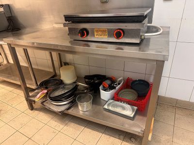 a stainless steel counter with pots and pans on it