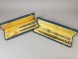 pair of silverware in a blue box on a white surface