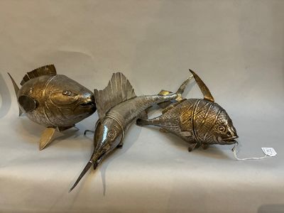trois poissons posés sur une surface blanche