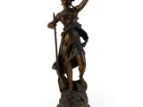 an antique bronze statue of a woman holding a staff on a pedestal