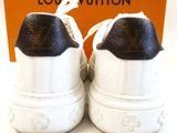 pair of louis vuitton white and black sneakers with a box in the background