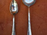 two spoons and a spoon rest on a table