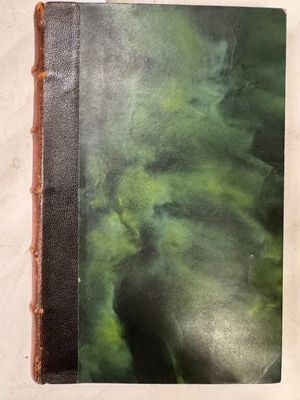 un vieux livre posé sur une table recouverte d'une couche d'eau verte