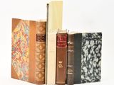 plusieurs vieux livres sont empilés sur une surface blanche