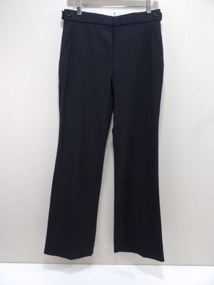 un pantalon noir suspendu à un cintre devant un mur blanc