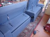 two blue couches in a room with a rug on the floor