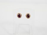 une paire de boucles d'oreilles en rubis et diamants, présentées sur un socle transparent