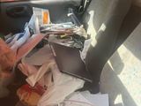 a car with a bunch of papers and a laptop on the back seat