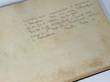 an old book with writing on it sitting on top of a table