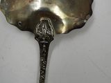 a silver spoon with a bird on it sitting on a table