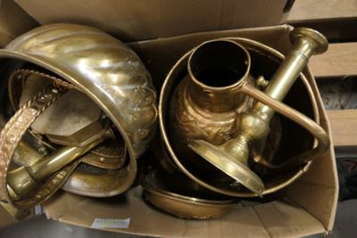 une boîte en carton contenant tout un tas d'objets en laiton