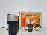 a coffee maker sitting next to a box on a table
