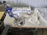 a white sewing machine sitting on a table in a room